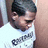 Pixelated close-up of a person with dark hair wearing a white shirt, partially cropped on the right side.