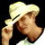 Pixelated static image of a person wearing a light-colored cowboy hat with dark band, brown skin tone, and visible shoulder/neck area against black background.