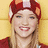 Pixelated close-up of a person with light brown hair wearing a red headband with a white square, smiling with visible teeth against a yellow background.