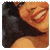 Pixelated close-up of a person's face with warm orange and brown tones, dark hair, and a blurred background.