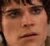 Pixelated close-up of a person's face showing eyes, nose, mouth, and dark hair against a blurred background.