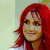 Pixelated portrait of a person with long red hair, light skin, and brown eyes against a pale background.