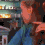 A pixelated animated sequence shows a person in a blue jacket with brown hair, transitioning from a side profile to a front-facing view against a blurred cityscape background.