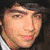 A static icon featuring a person with dark hair in three distinct poses: close-up, shoulder pose, and stage performance.