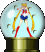 Sailor Moon character in a snow globe with golden base, red boots, blue skirt, and yellow hair, surrounded by small flying objects.