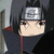Anime character with black hair and red eyes wearing a dark cloak with red lining and silver headband featuring circular symbol.