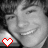 A grayscale portrait of a smiling person with short hair, featuring two red pixelated heart icons at the bottom left and center.