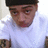 Pixelated close-up of a person wearing a black cap and light blue shirt with visible shoulder details.