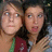 Two people with light skin tones and dark hair appear in a close-up, pixelated image; one wears a maroon garment with green accents.