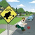 Pixelated image of a yellow diamond-shaped road sign with black arrow, person in white shirt and green pants running on sidewalk near street.