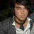 A pixelated image shows a person with dark curly hair wearing a gray jacket over a white shirt and black choker, next to green text reading "I Love Joe Jonas" on a black background.