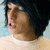 Pixelated side profile of a person with dark hair against a light blue background, wearing a light-colored top.
