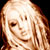 Static pixelated image of a person with light brown hair and fair skin, cropped to show upper face and shoulders against dark background.