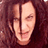 Pixelated static image of a person's face with visible facial features and dark hair against a maroon background.