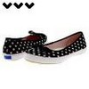 Black and white polka dot flat shoes with white soles and brown interior, displayed against a white background with three black heart icons above.