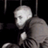 Pixelated grayscale image of a stylized human figure with rounded head and body, partially obscured by motion blur or low resolution against dark background.