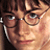 A pixelated close-up of a person with brown hair and glasses, showing the right eye, nose, and mouth area with a neutral expression.