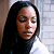 Static pixelated image of a person with long dark hair against a light background, rendered in low resolution with visible dithering and color banding.