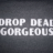Static pixelated text on dark gray background reads 'DROP DEAD GORGEOUS' in white block letters.