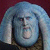 Pixelated static image of a character with light blue hair and dark facial features against a maroon background, rendered in low-resolution 50x50 dimensions.