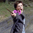 A person in dark clothing holds a wand-like object, with pink text changing across frames from 'my' to 'hero' to 'is' against a blurred outdoor background.