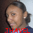 Pixelated close-up of a person with dark hair tied back, wearing a dark blue top with light blue accents, red text overlay at bottom.