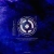 A pixelated circular icon with concentric rings of light gray and white on a dark blue background, appearing static.