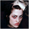 A person with dark hair and heavy eye makeup holds their hand to their head, displaying three variations of text above them.