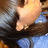 A person with long dark hair and a gold earring wears a blue top, viewed from above in a of four