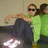 Two figures in a pixelated image: one wearing dark pants and white shoes, the other in green shirt and sunglasses with arms around each other.