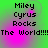 Green and pink gradient background with repeated text blocks reading "Miley Cyrus Rocks" and "The World!!!!!" in pixelated font.