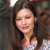 A static pixelated image shows a person with long dark hair, closed eyes, and a slight smile, wearing a light-colored top with a patterned design.