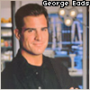 Pixelated portrait of a man in a black shirt with arms crossed, set against a blurred background featuring shelves and lights, with text reading 'George Eads' at the top.