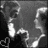 Black-and-white pixelated image with red lines, featuring a partial face and heart symbol alongside text fragments