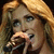 A woman with long blonde hair singing into a microphone, shown in four with slight variations in facial expression and mouth position