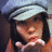 A pixelated image shows a person wearing a light gray cap and dark hair, with an orange background containing blue text reading 'Air Kisses' and a heart symbol.