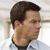 Pixelated profile view of a person with short dark hair wearing a light-colored shirt against a blurred background.
