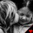 Black-and-white image of a child with light hair in repeated pattern, red plus sign on black triangular background