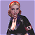 A pixelated image of a woman with blonde hair and red highlights wearing a black jacket over a low-cut top, standing against a light purple background next to green text reading "Original Icons .com".