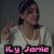 A person in a white hoodie and pink top makes a peace sign with their right hand, wearing a headband and necklace.