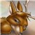 Brown-furred animal with large ears and a long nose, facing left, against a blurred background of light and dark tones.