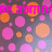 Pixelated image with pink and orange circular shapes on a gradient background, featuring partially visible pink text at the top.
