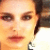 A pixelated close-up of a person's face with light skin, brown eyes, and dark hair partially visible on the right side.