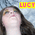 A four- shows a person with long brown hair and yellow eyeshadow looking upward against a light blue background, with text overlays reading LUCY IN THE SKY WITH DIAMONDS