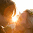 A pixelated static image shows a bright central light source surrounded by warm orange and brown tones with no distinct subjects or text.
