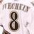 White sports jersey with brown text 'FECHEZ' and black number 8 outlined in beige, displayed as a static image.