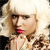 Pixelated close-up of a person with light hair and red lips, wearing a light-colored top with a brown patterned design.