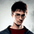 Pixelated portrait of a person with short dark hair, wearing a dark jacket over a red shirt against a light gray background.