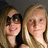 Two people with light brown hair pose closely together against a dark background, one wearing dark sunglasses and the other with visible eyes and a slight smile.