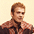 Pixelated image of a person with light brown hair wearing a checkered shirt, next to green text on dark background.